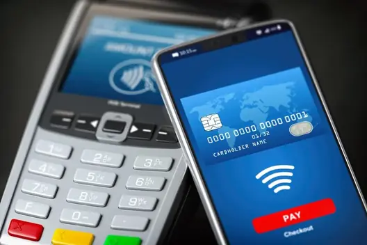 Mão a usar pagamento NFC com telemóvel em ambiente tecnológico