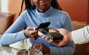 Mulher a pagar conta de restaurante com telemóvel